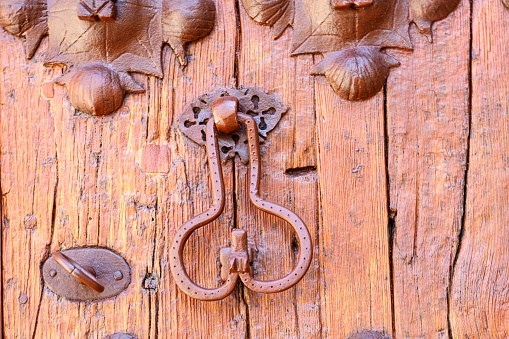 Old metal knocker on wooden door