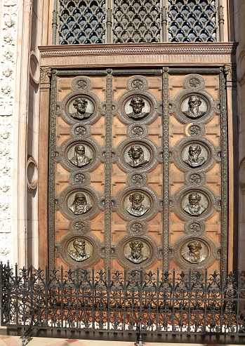 Budapest, B, Hungary - August 19, 2023: wooden gate with faces at St Stephen s Basilica in Budapest  Hungary