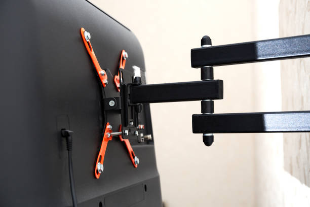 istock Swivel TV bracket LED display. Back view. X-shaped red fasteners. Black color. Multiplanar. Hangs on a wall. Reliable and comfortable fastening. Childproof and rollover protection. Metallic equipment 1800320389