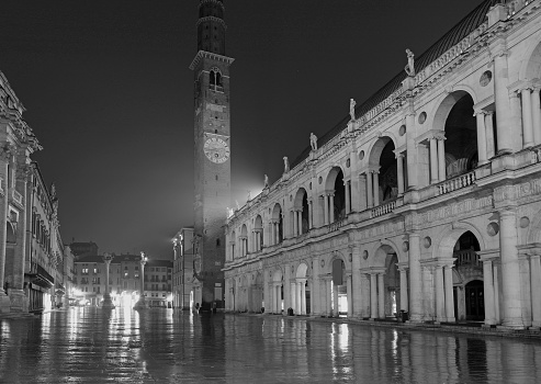 Vicenza, VI, Italy - January 15, 2023: Night view of the historic center with the main square with reflections of street lamps after the rain