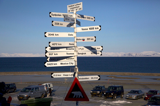 Signs show the direction and distance to various cities around the world at Svalbard Airport Longyearbyen, Svalbard, Norway.