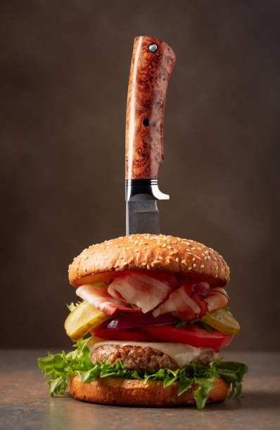 istock Fresh burger with knife on a brown background. 1800342582