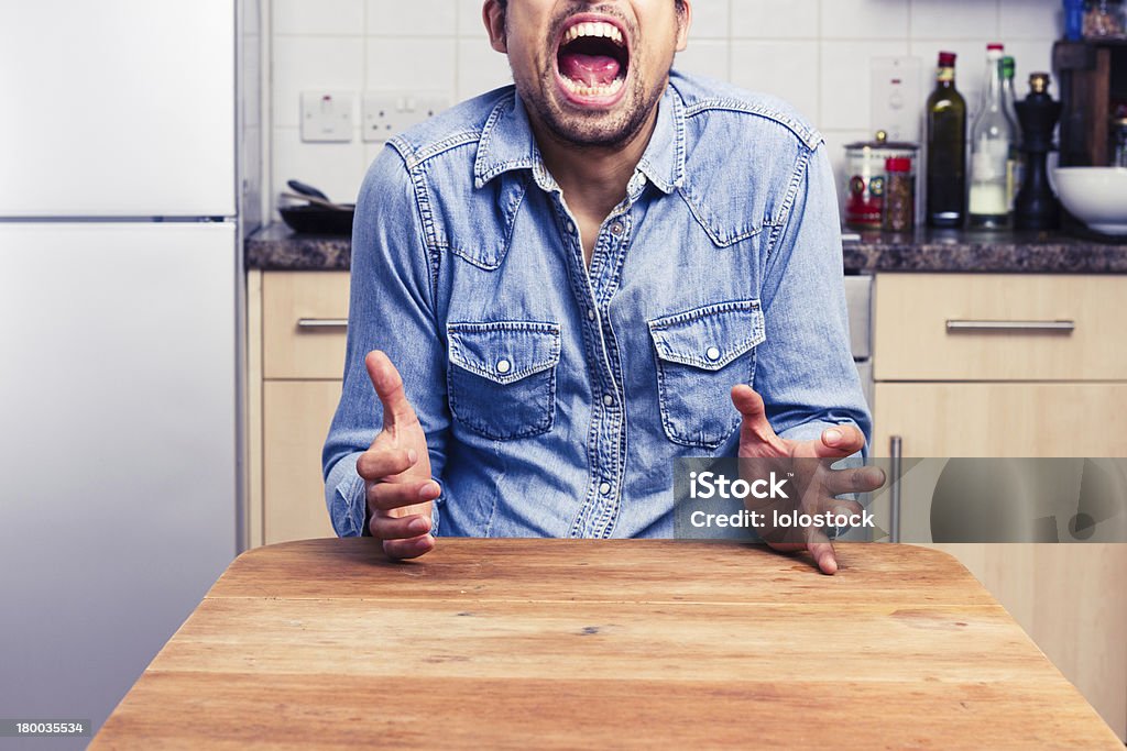 Homem gritando balançando um bastão com as mãos em sua cozinha - Foto de stock de Adulto royalty-free