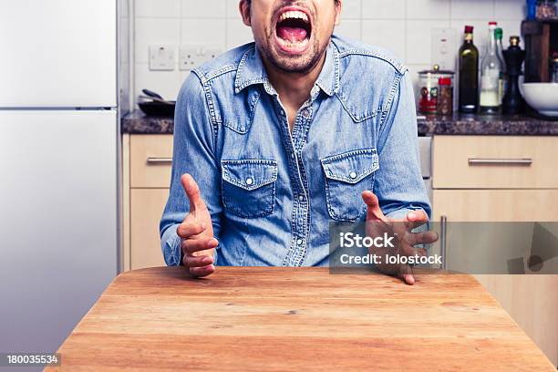 Foto de Homem Gritando Balançando Um Bastão Com As Mãos Em Sua Cozinha e mais fotos de stock de Adulto