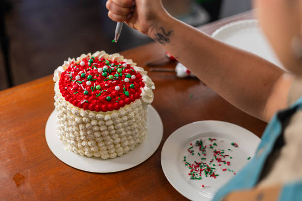 The chef prepares a beautiful and delicious cake for Christmas while in her kitchen using her preparation implements