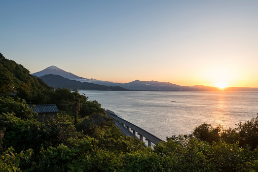 Mt. Fuji and expressway seen from Satta Toge pass at sunrise with reflection on sea, Shimizu, Shizuoka, Japan. Famous photography top view spot for tourist people.