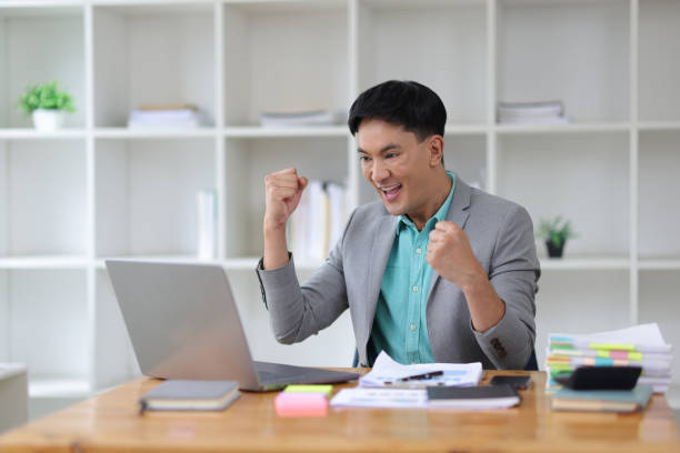 istock Excited and happy businessman working in office after successful goal work. 1800445094