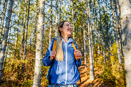 Smiling hiker woman with a backpack on a hiking route