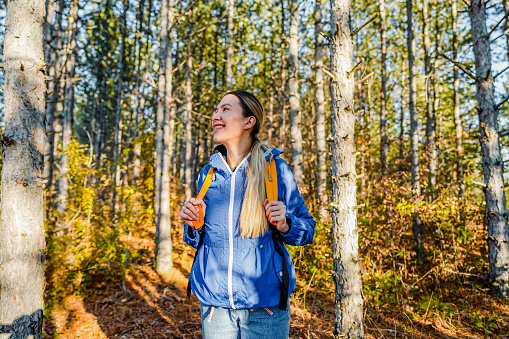 Smiling hiker woman with a backpack on a hiking route
