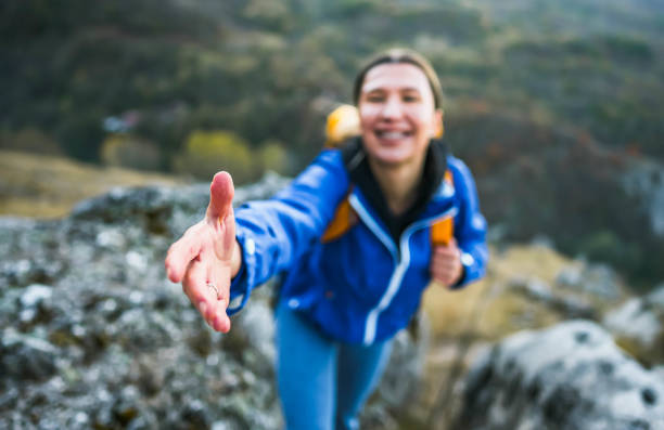 istock Hiker woman reaching for someone's hand 1800454334