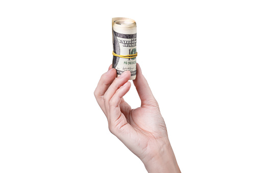 A hand holding a roll of money isolated on on white background