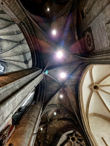 Narbonne Cathedral is a Roman Catholic church located in the town of Narbonne, France. The cathedral is a national monument and dedicated to Saints Justus and Pastor. The image shows the ceiling of the gothic church.