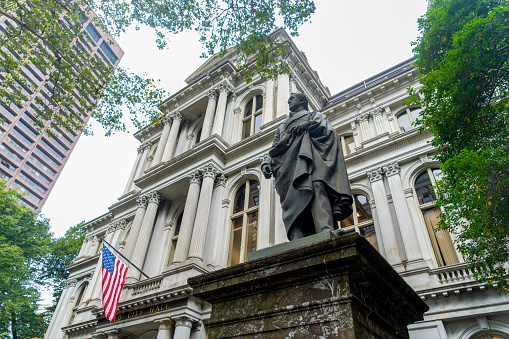 Sign on the statue of Josiah Quincy outside Boston city Hall on School Street.