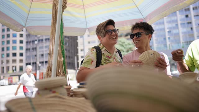 Tourist gay couple buying craft products at a street market