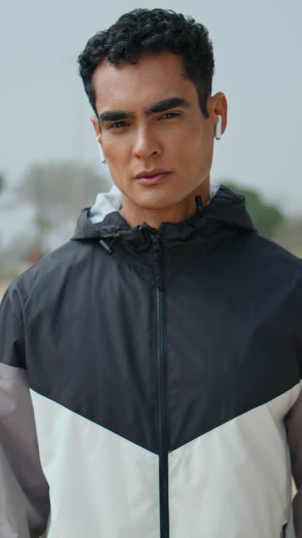 Man athlete zip jacket in urban park vertically. Handsome sportsman look camera