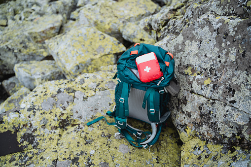 Traveler's backpack in the wilderness, first aid kit lying on backpack, hiking survival kit. Trekking in the mountains. High quality photo