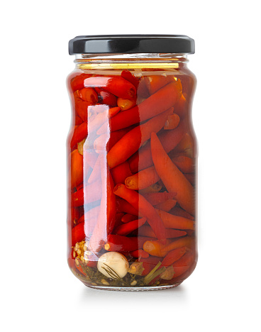 red chili pepper canned in a glass jar isolated on white background with clipping path