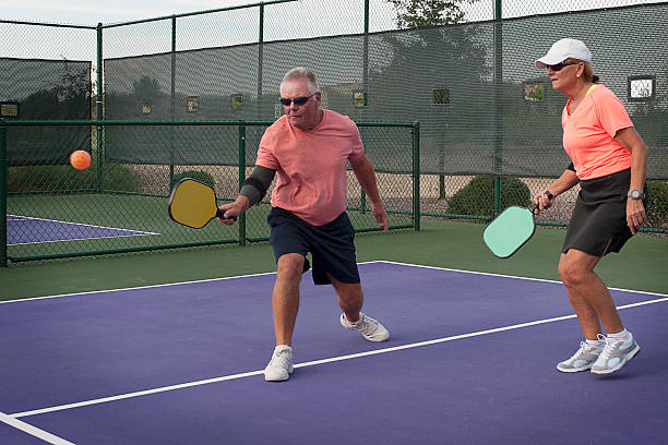 juego de dobles mixtos pickleball acción-lisas revés - paddle ball racket ball table tennis racket fotografías e imágenes de stock