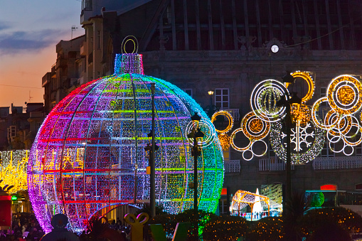 Street light Christmas decorations, large illuminated Christmas tree ball and tinsel in Vigo, Galicia, Spain.