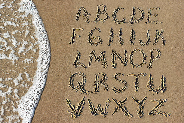 Sand Alphabet and Sea stock photo