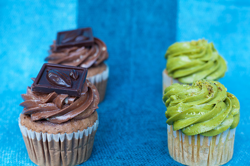 Chocolate and pistachio cupcakes on a blue background