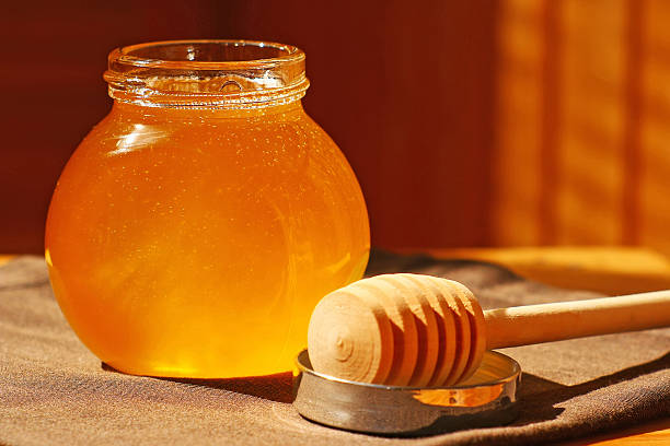 istock Glass jar with honey and wood stick 180076001