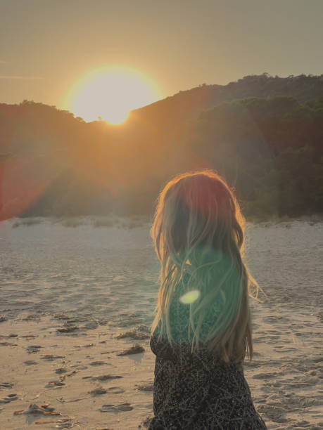 istock woman alone on a beach at sunset on an island. 1800760837