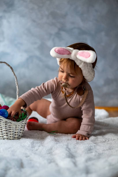 kleines mädchen spielt mit ostereiern - bunny girl stock-fotos und bilder