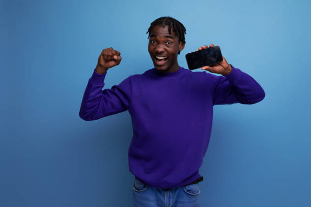 istock modern black american young guy with dreadlocks uses phone for online payments 1800792639
