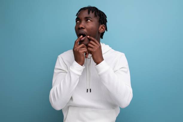 istock puzzled dark-skinned young brunette male in studio isolated background 1800793172