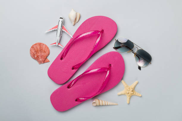 istock Flip flops with sunglasses and airplane on color background, top view 1800801613