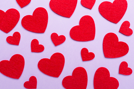 Felt hearts on color background, top view