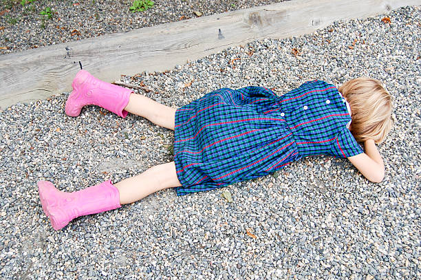 Sad girl lying on the ground stock photo