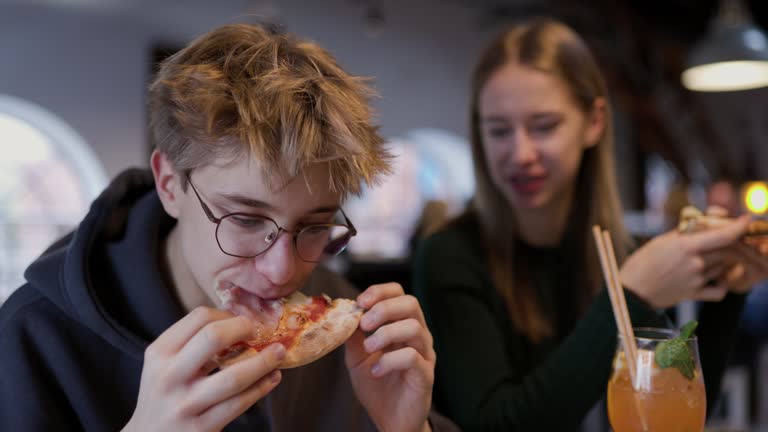 Teenagers enjoying lunch in a pizza restaurant.