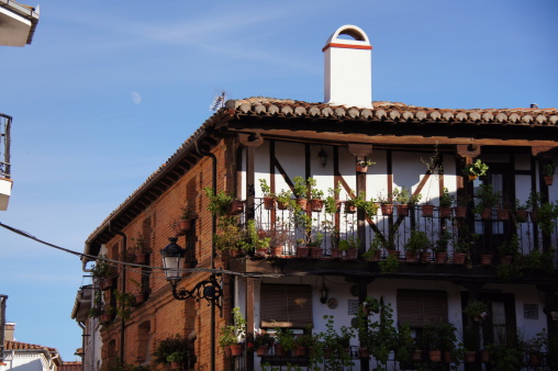 Typical house of brick with visible structure of wood, roof of Arabic tiles, brick fireplaces, sherds and flowers, wooden galleries, typical spanish lanterns, dishes and ceramic tiles, cane blinds, Candeleda, Spain