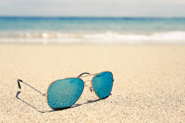 istock Sunglasses on sandy beach in summer - vintage color styles 1800882113