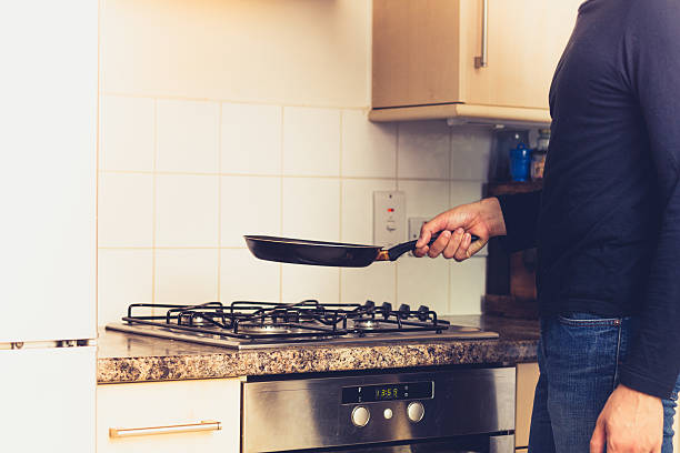 Food in a metal frying pan being stirred with a spoon, close-up.