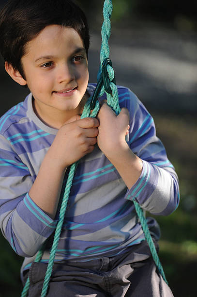 istock Child playing with swing in a park 180094197