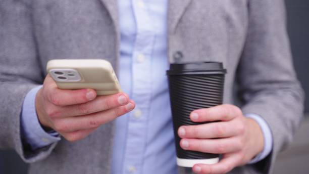 istock Young man typing on the phone while holding coffee. Slow motion 1800946186
