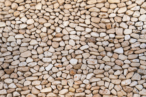 Background with a wall made of oval-shaped stones