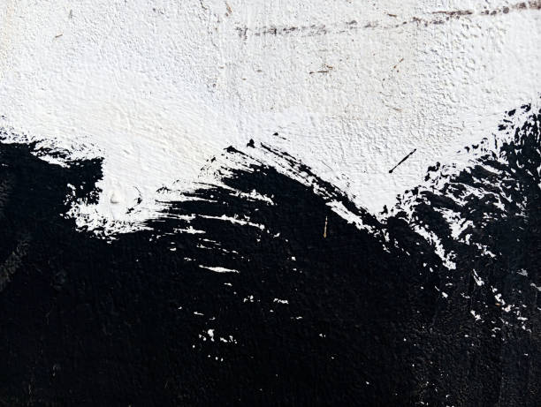 istock Black paint stains on cement wall. Abstract black paint grunge background. Paint texture with copy space. Stained concrete wallpaper. Brush painted black and white illustration. 1800960747