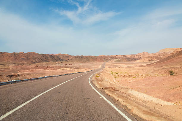 estrada no deserto - arid climate asphalt barren blue - fotografias e filmes do acervo