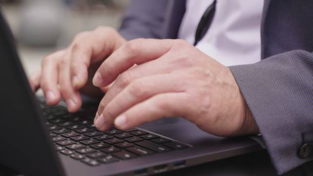 istock Man using laptop and headset while sitting in the city. Slow motion 1800981200