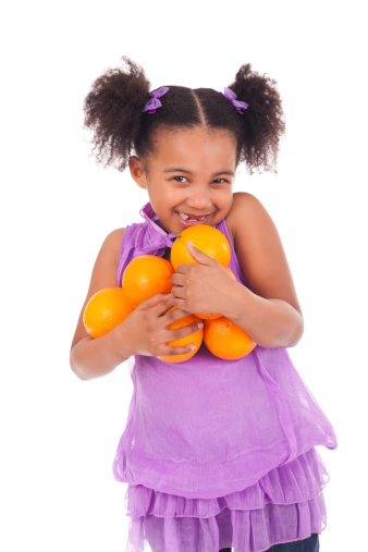 young girl smiling with orange fruit