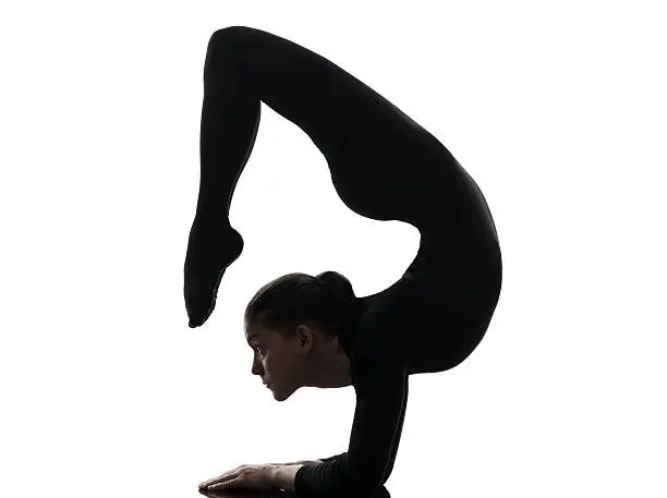one caucasian woman contortionist practicing gymnastic yoga in silhouette on white background