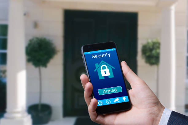 istock man controls smart home devices using app for mobile phone on background of the front door. concept of digitalization. a mockup with hand holding phone. 1800997052