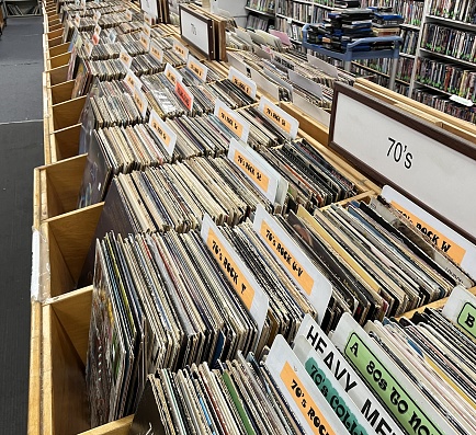 Bins and rows of large 33 record albums on display for sale from different angles.