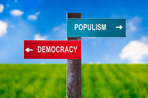 Populism vs Democracy - Traffic sign with two options - voting for establishment and mainstream democratical party vs electing demagogical populist politicians and politics.