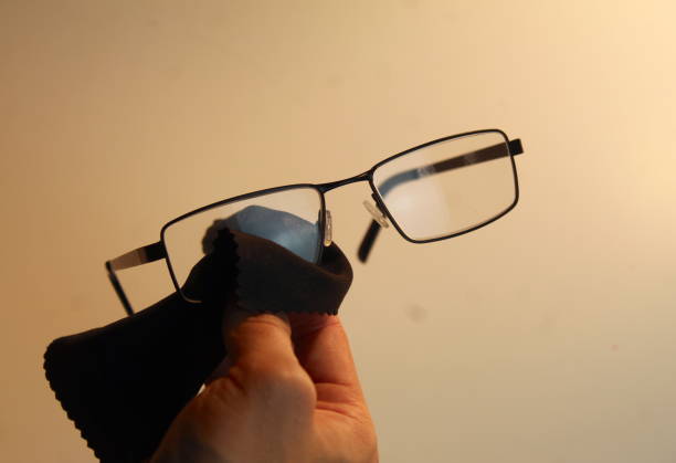 istock Person cleaning their black glasses with microfibre cloth 1801029245