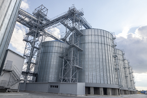Modern industrial grain Elevator for grain storage. Steel silos for storing grain on a agricultural farm.